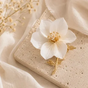 Broche artesanal con flor blanca inspirada en la naturaleza sobre piedra travertino y lino beige