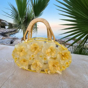 Bolso artesanal elegante con narcisos naturales encapsulados y asas de bambú.