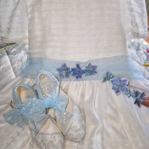 Cinturón artesanal para vestido de comunión confeccionado con flores preservadas de hortensia en tono azul cielo.