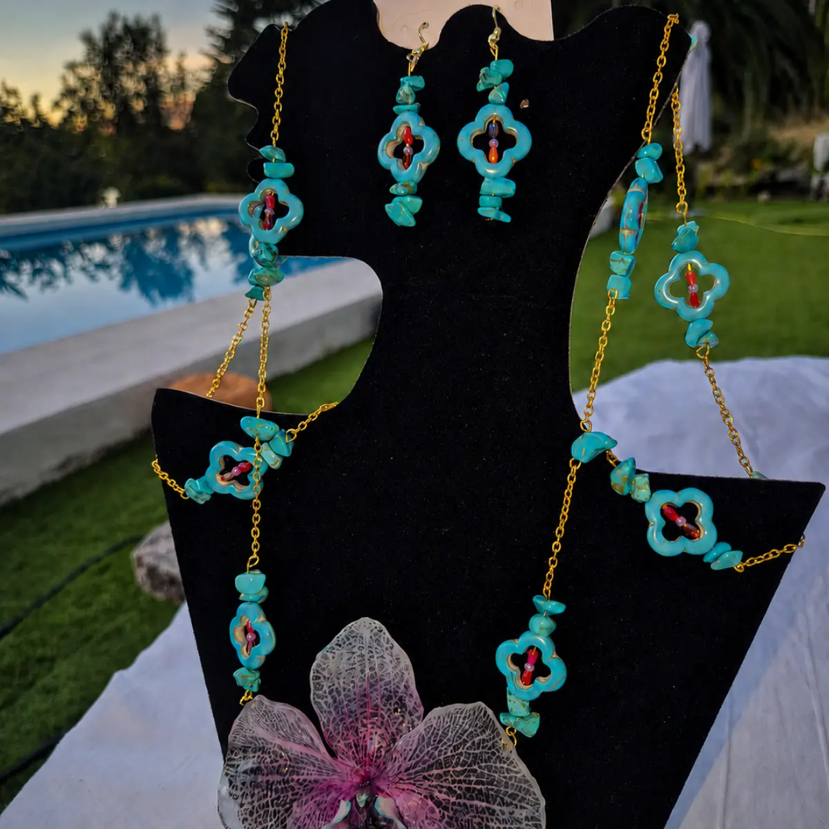 Detalle de los pendientes de turquesa con forma de trébol de cuatro hojas y cristales del conjunto artesanal Galaxia.