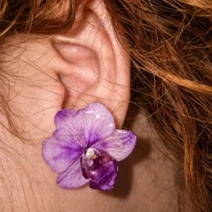 Mini pendientes de pétalos de orquídea natural fucsia y lila encapsulados en resina transparente.